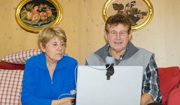 Äldre par med anteckningsboken för videosamtal — Stockfoto