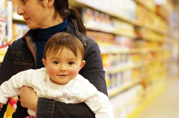 Babymädchen mit ihrer Mutter in einem Geschäft voller Spielzeug — Stockfoto