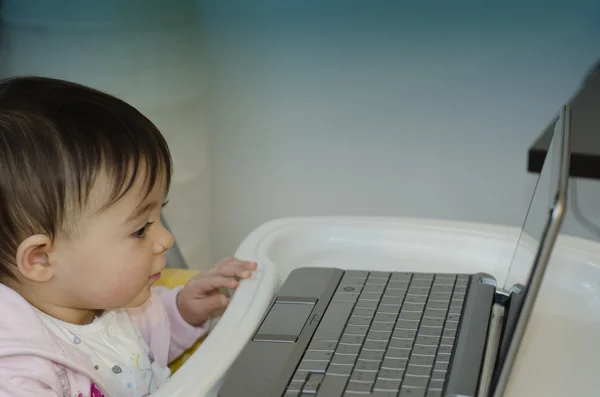 1 år baby flicka som försöker använda sin netbook — Stockfoto