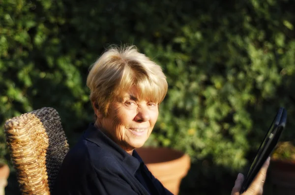 Emekli kadın onun smartphone ile açık rahatlatıcı — Stok fotoğraf