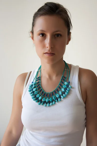 Žena v bílém horní a tyrkysová náhrdelník — Stock fotografie