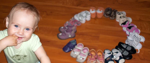 Engraçado bebê menina e ela um monte de sapatos — Fotografia de Stock