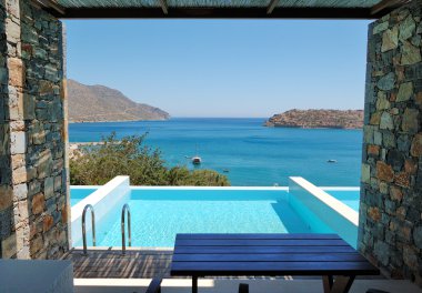 Swimming pool by luxury villa with a view on Spinalonga Island, clipart