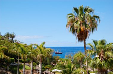 Beach at luxury hotel and sail yacht, Tenerife island, Spain clipart