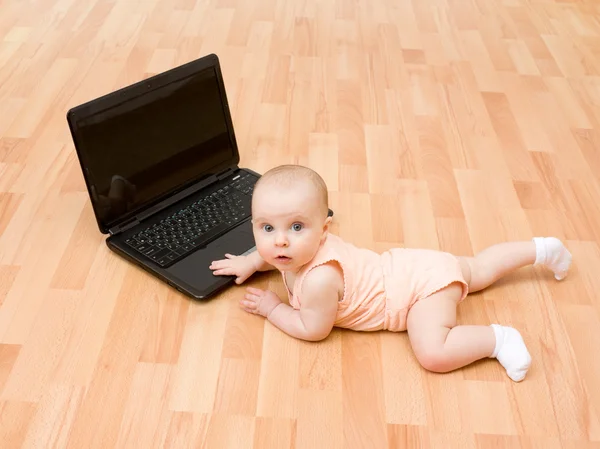 A criança com o computador portátil . — Fotografia de Stock