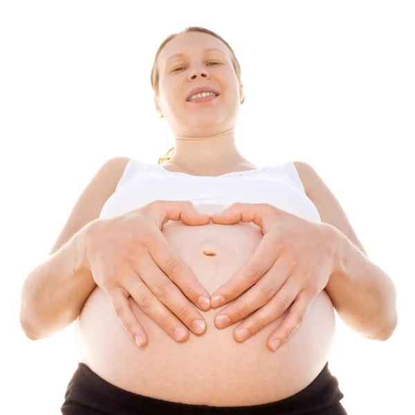 Eine schwangere Frau und ihre Hände in Herzform. — Stockfoto