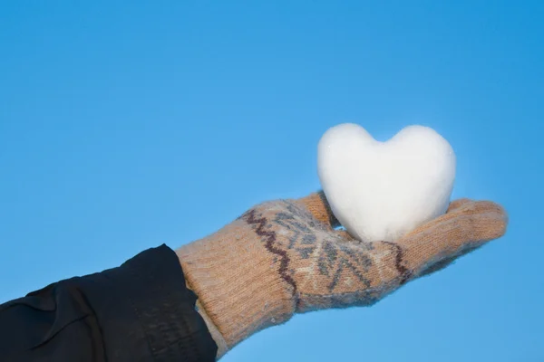 Ein schneebedecktes Herz an seinen Händen. — Stockfoto