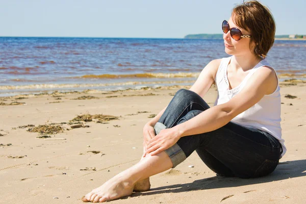 Femme en lunettes de soleil sur la plage. — Photo