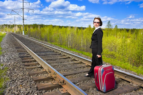 A woman with a suitcase at the railway. — Stock Photo, Image