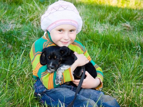 Het meisje met de puppy in haar armen. — Stockfoto