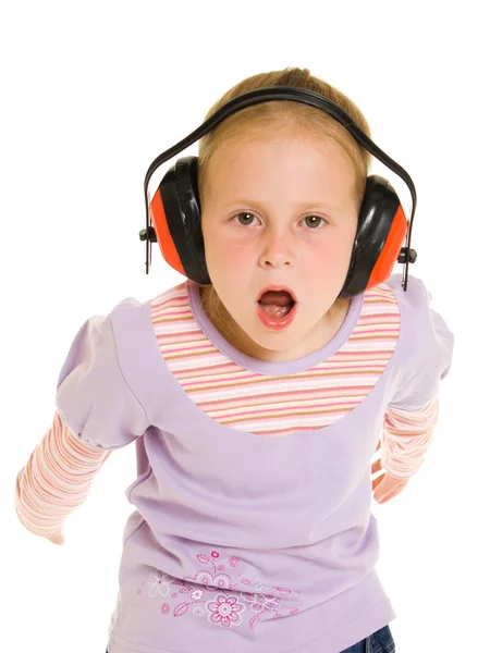 Liten flicka lyssnar på musik på vit bakgrund — Stockfoto