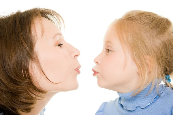 Мама и дочь целуются на белом фоне . — стоковое фото