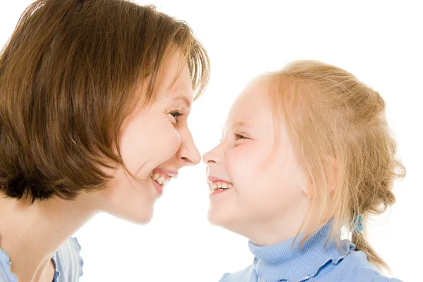 Moeder en dochter glimlachen bij elkaar op een witte achtergrond. — Stockfoto
