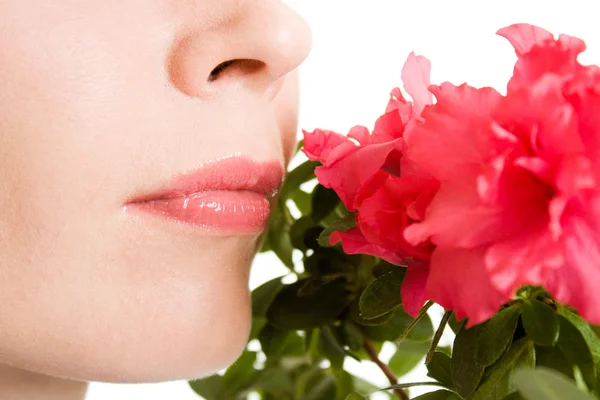 Flicka att lukta en blomma på en vit bakgrund. — Stockfoto