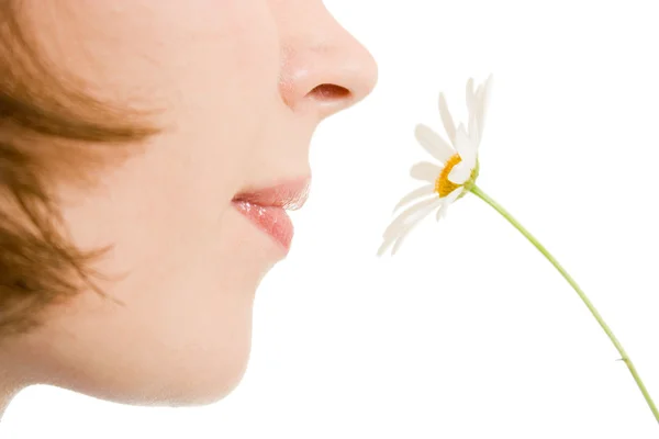 Menina cheirando uma flor em um fundo branco . — Fotografia de Stock