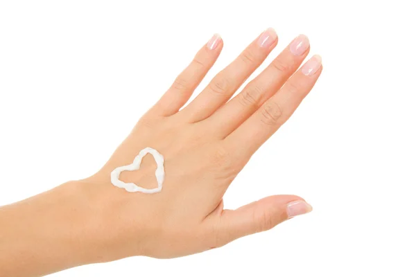 La crema en la mano femenina sobre el corazón . —  Fotos de Stock