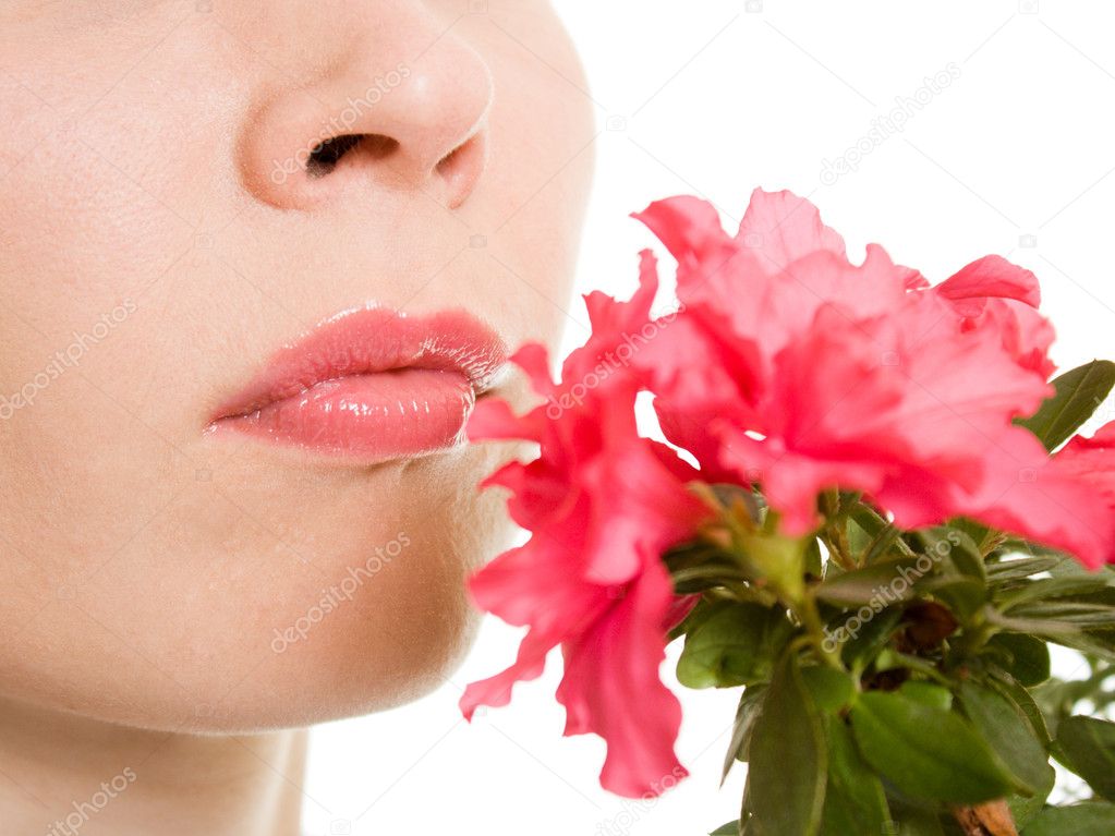 Girl smelling a flower on a white background.