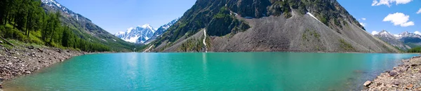 Горное озеро на заднем плане с высокой горой — стоковое фото