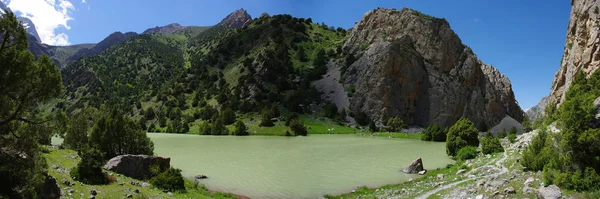 Горное озеро на заднем плане с высокой горой — стоковое фото