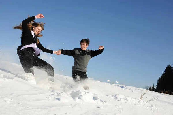 Teenagers run through snowdrift — Stock Photo, Image