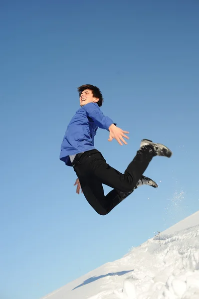 Прыгающий подросток в синей рубашке и черных джинсах — стоковое фото