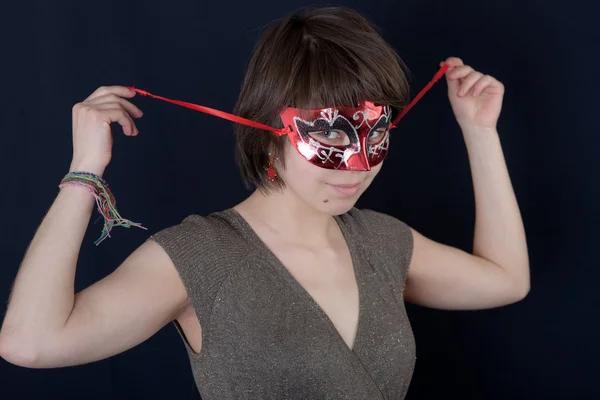 Menina em uma máscara vermelha — Fotografia de Stock
