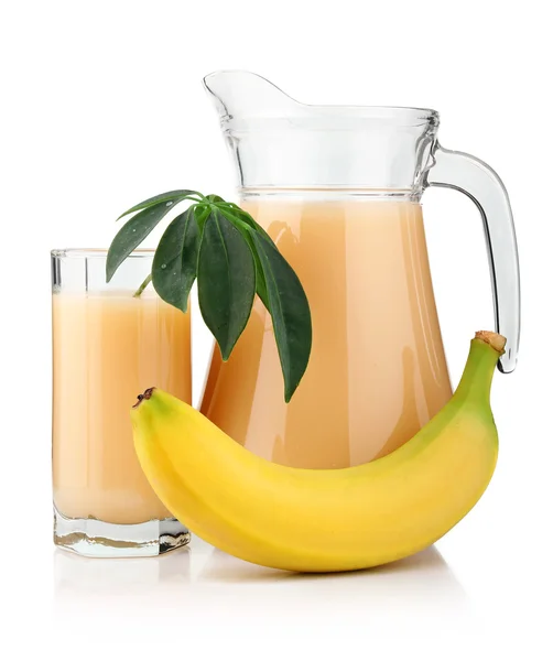 Vaso lleno y jarra de zumo de plátano y frutas aisladas — Foto de Stock