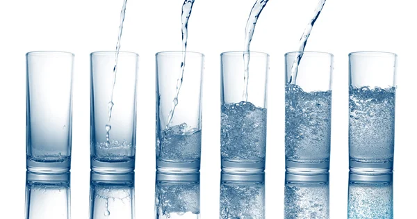 Wylewanie wody słodkiej fajne w szklance na białym tle — Zdjęcie stockowe