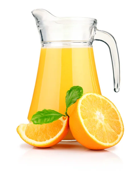 Kruik van sinaasappelsap en oranje vruchten met groene bladeren — Stockfoto