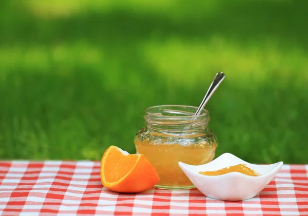 Jar of orange jam in the summer garden — Zdjęcie stockowe