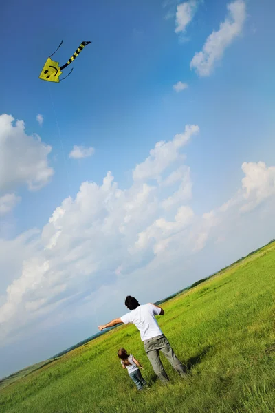 Klein meisje en haar vader met vliegen een vlieger — Stockfoto