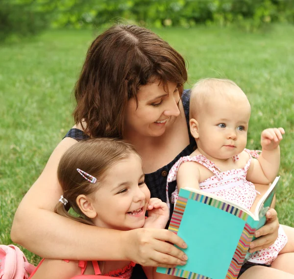 Mother and children reading a book i — Stock Photo, Image