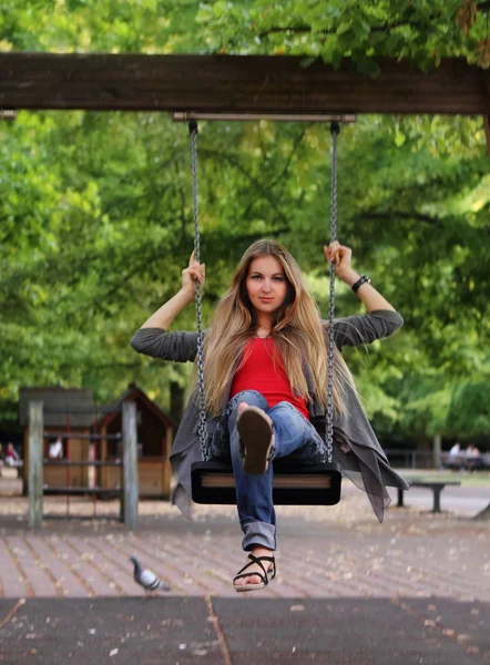 Leende flicka på swing i höst park — Stockfoto