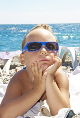 Sahilde erkek güneş gözlüğü sunbathes