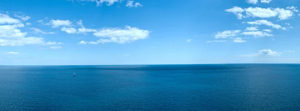 Panorama de un paisaje marino con nubes blancas y el agua azul tranquila —  Fotos de Stock
