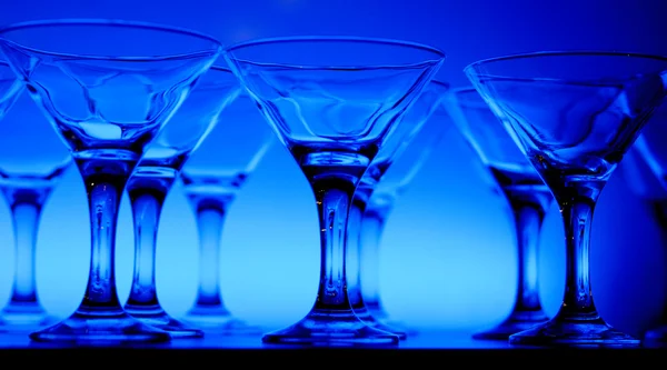 Weingläser im Blaulicht auf dem Tisch — Stockfoto