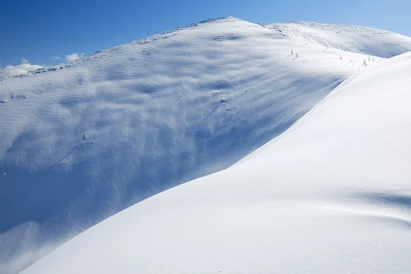 A encosta de neve nas montanhas — Fotografia de Stock