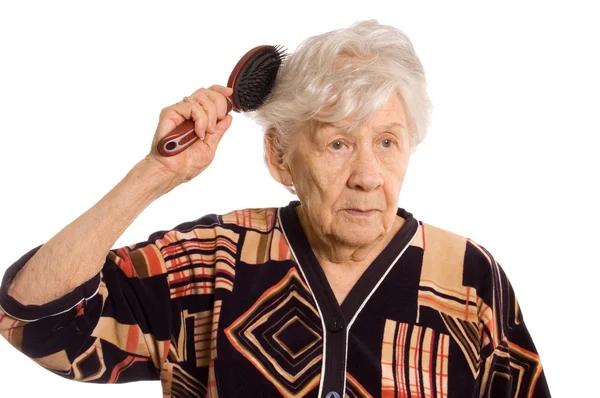 Starší žena kartáče vlasy — Stock fotografie