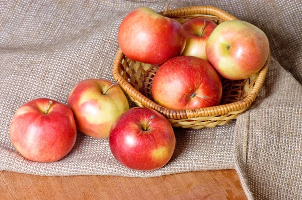 Äpplen på en säckväv på ett träbord — Stockfoto