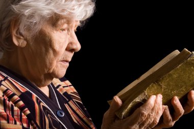 The elderly woman reads the book clipart