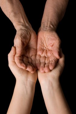 Hands of the old woman on a black background clipart