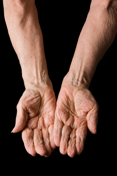 Руки старухи на черном фоне — стоковое фото