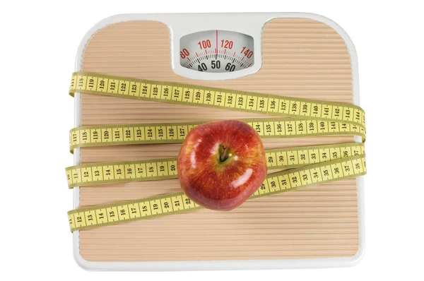 Масштаб, лента и яблоко на белом — стоковое фото