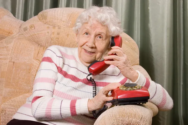 Az idős nő beszél a telefonon Stock Kép