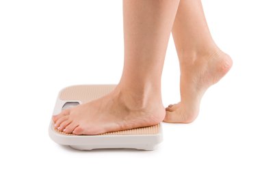 Female feet on scales isolated clipart