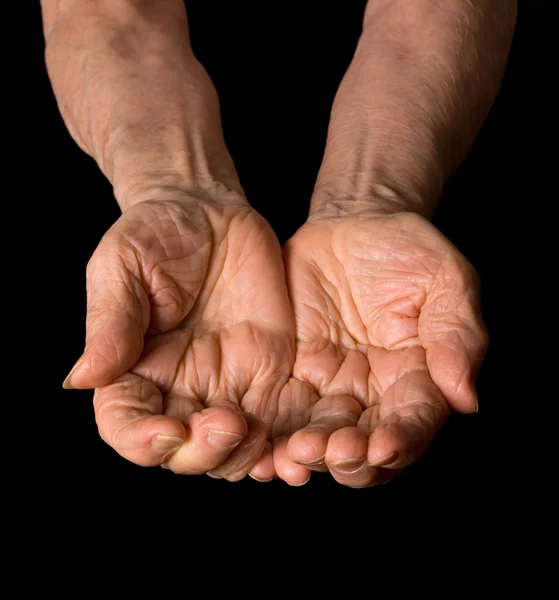 As mãos da velha mulher em um fundo preto — Fotografia de Stock