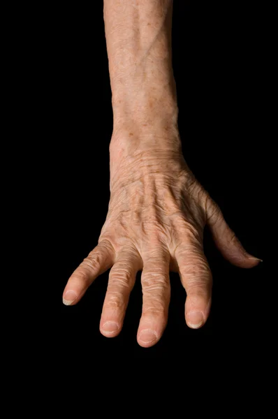 Les mains de la vieille femme sur un fond noir — Photo