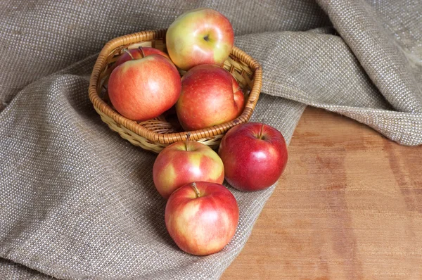 Яблоки на мешке на деревянном столе — стоковое фото