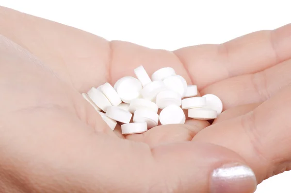 Hand med ett piller på vit — Stockfoto