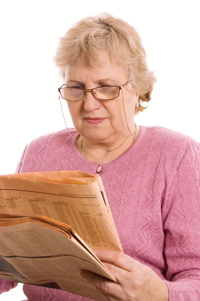 The elderly woman reads the newspaper — Stock Photo, Image
